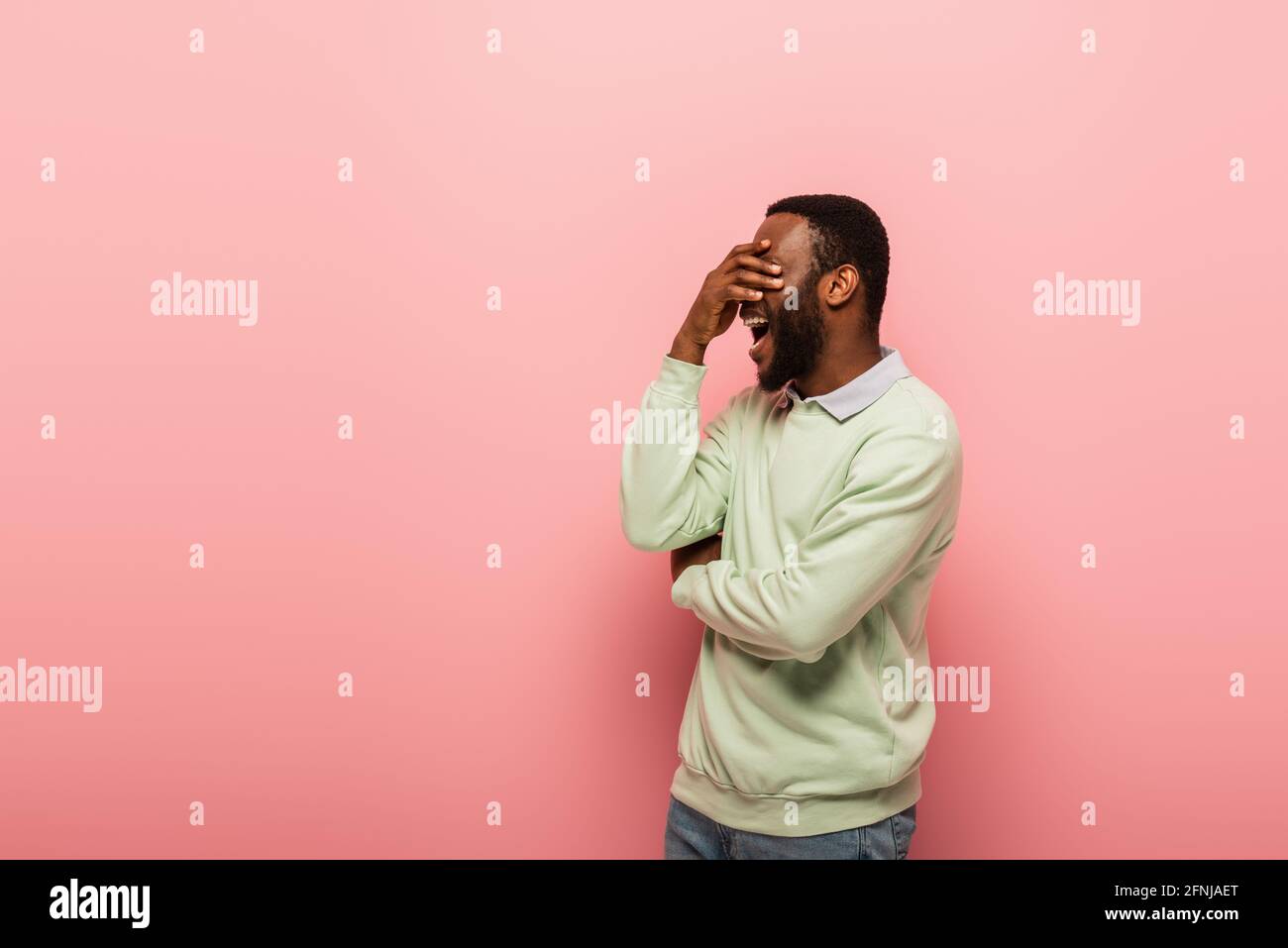 Shocked african american man covering eyes on pink background Stock ...