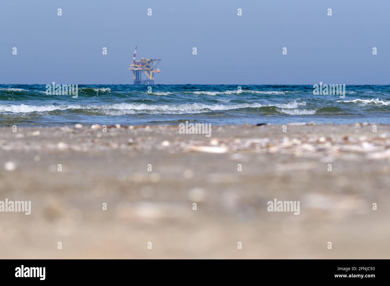 Ameland,Netherlands April 20,2021-NAM, Oil rig, offshore platform with beach, sand and surf. Natural gas extraction in the Wadden-North Sea Region Stock Photo