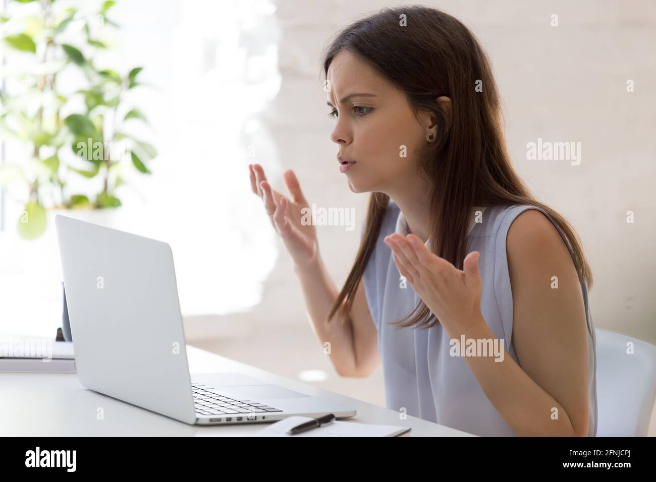 Unhappy millennial woman frustrated with computer problems Stock Photo