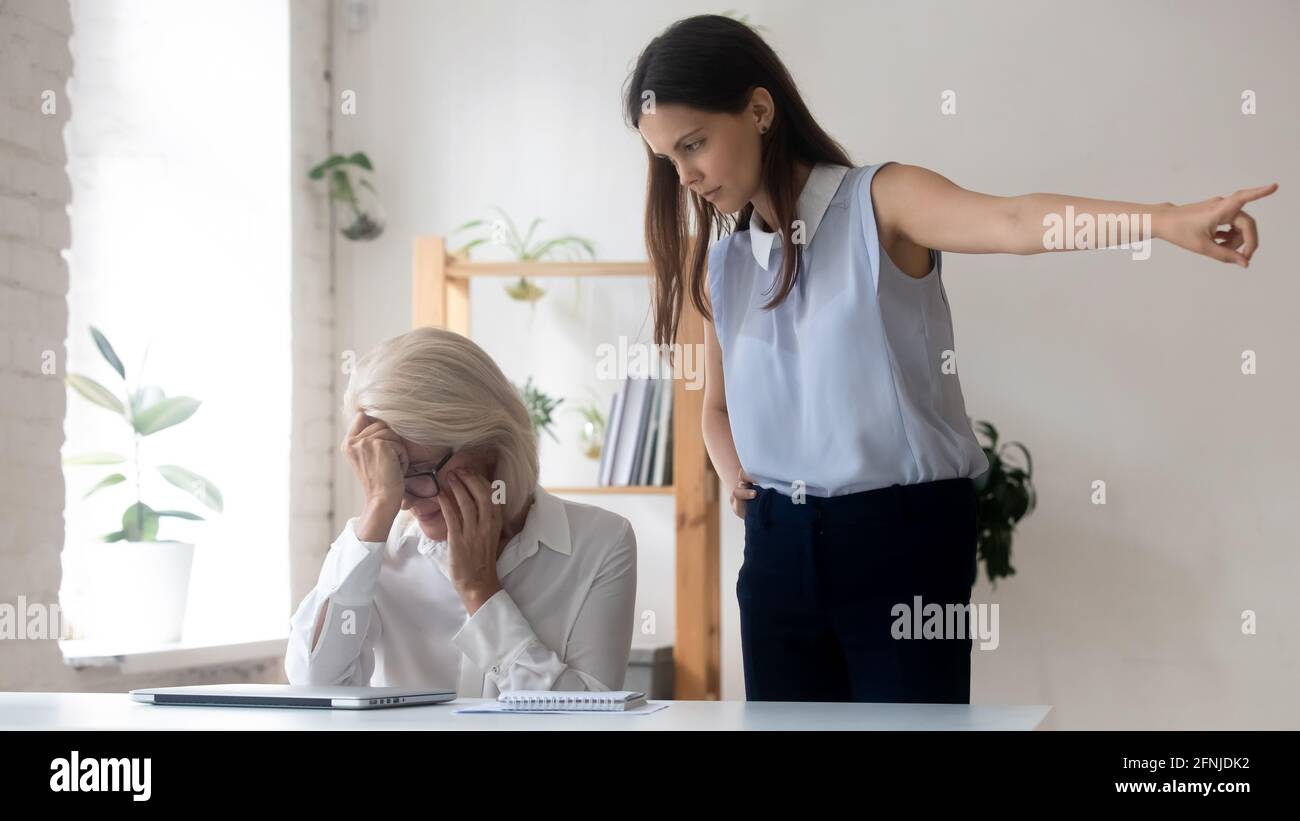 Angry young businesswomen fire middle-aged female employee Stock Photo