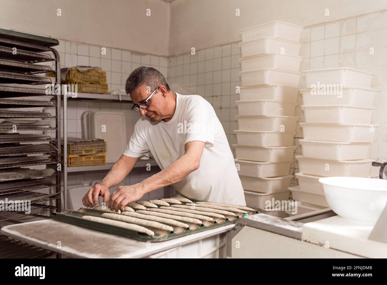 Bakery Making old authentic baker in bakery making organic bread and taking care of ...