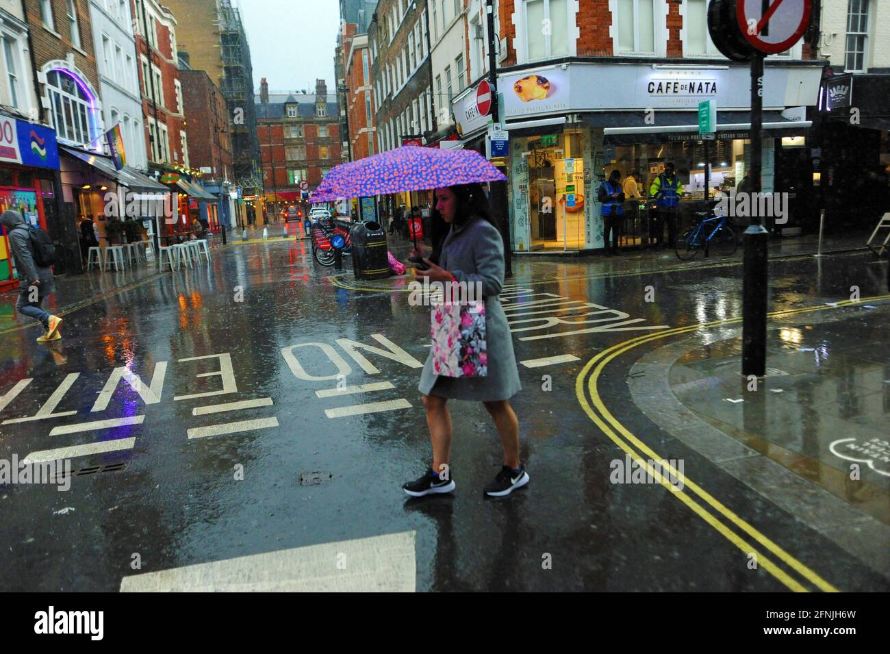 London, UK. 17th May, 2021. Old Compton street in Soho restaurants empty on first day after removal of lockdown restrictions. Heavy rain dampens first day of lockdown freedom in West End. Credit: JOHNNY ARMSTEAD/Alamy Live News Stock Photo