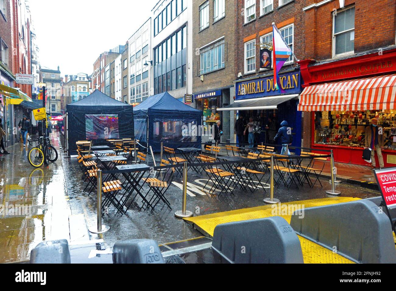 London, UK. 17th May, 2021. Old Compton street in Soho restaurants empty on first day after removal of lockdown restrictions. Heavy rain dampens first day of lockdown freedom in West End. Credit: JOHNNY ARMSTEAD/Alamy Live News Stock Photo