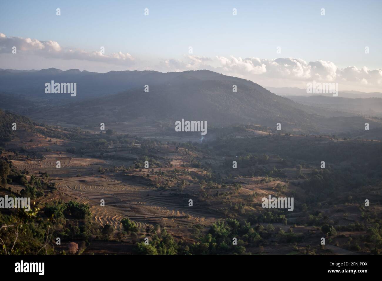 Viewpoint looking out over a beautiful valley landscape with terraced rice fields farm lands during evening sun between Kalaw and Inle Lake, Shan stat Stock Photo