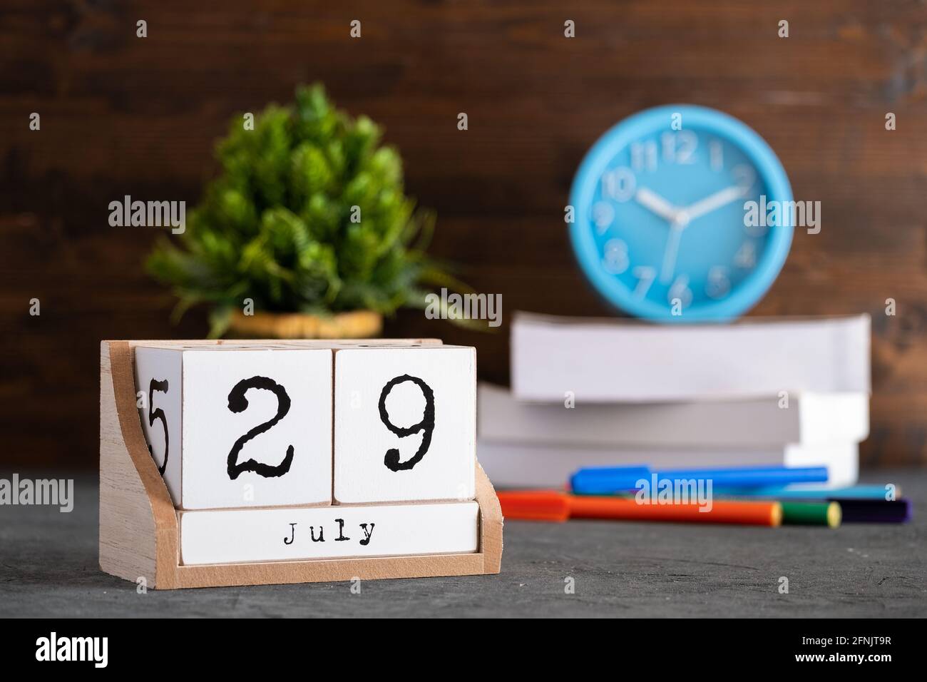July 29th. July 29 wooden cube calendar with blur objects on background. Stock Photo