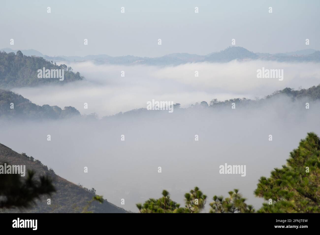 View over mist in a valley with rolling hilles in distance layers between Kalaw and Inle Lake, Shan state, Myanmar Stock Photo