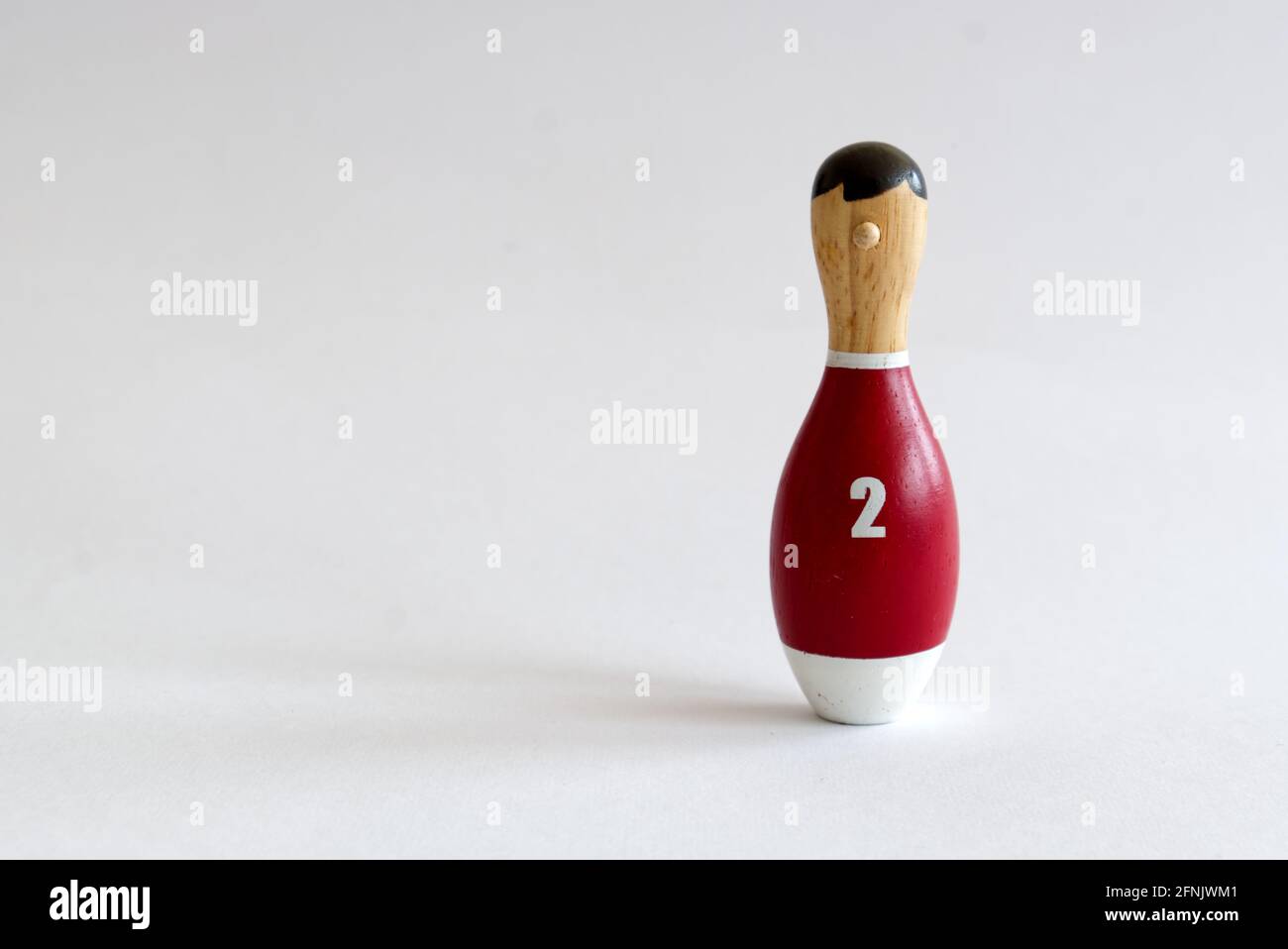 a wooden puppet in the shape of a bowling pin with a number two shirt Stock Photo