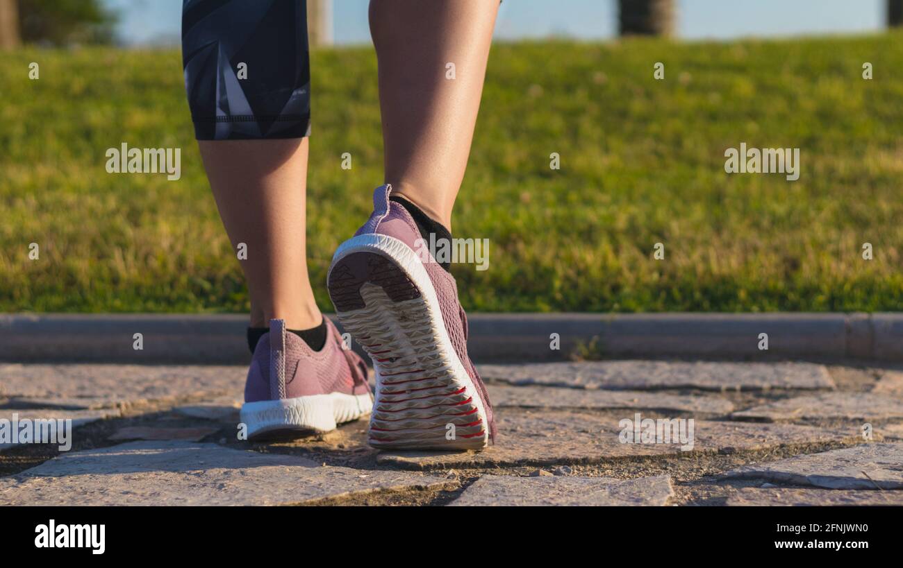 Athlete runner feet running in nature, closeup on shoe. Woman fitness jogging, active lifestyle concept Stock Photo