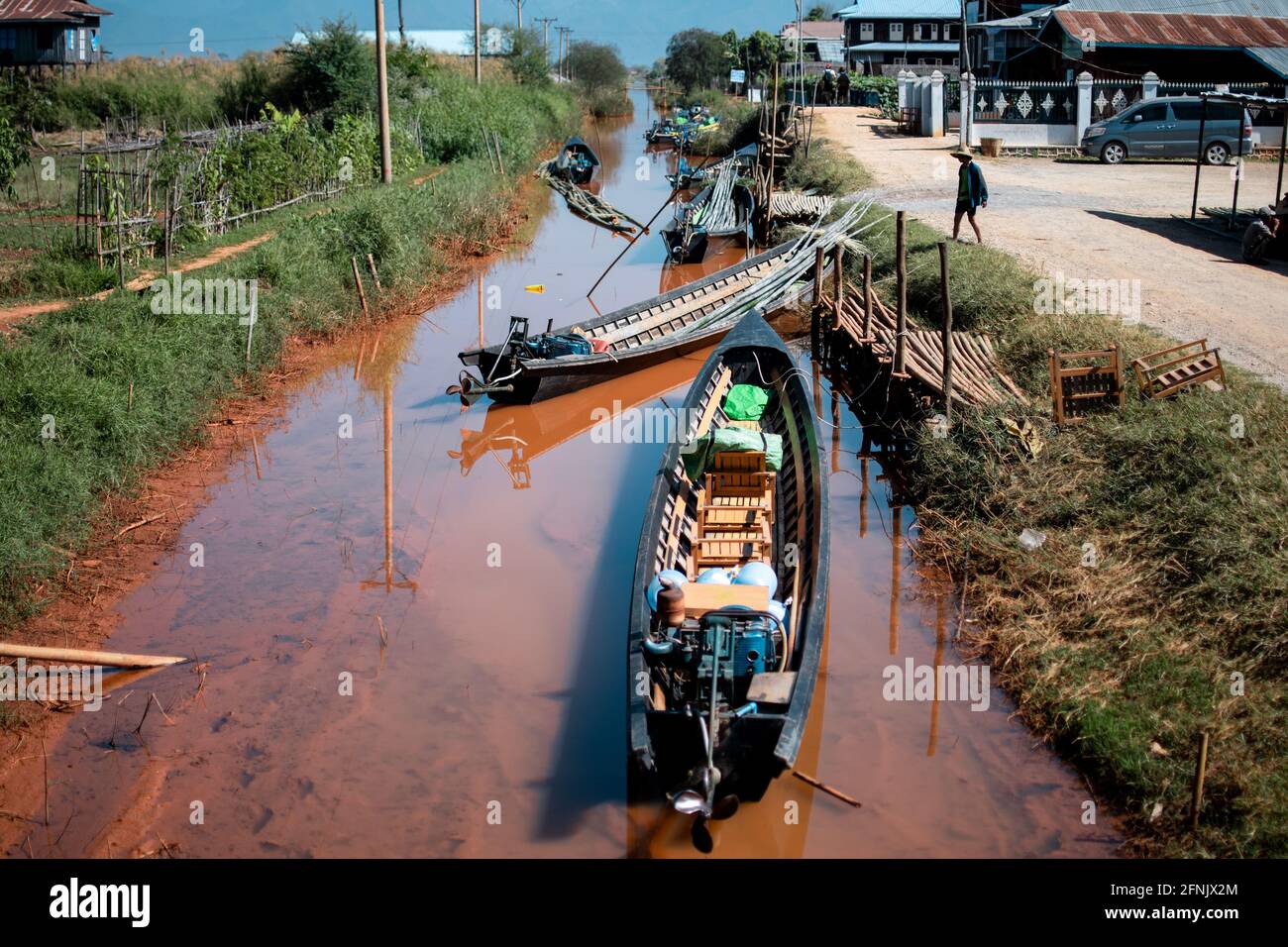 Shan state, Myanmar - January 7 2020: Traditional boats in a narrow muddy canal in a village near Inle Lake, Nyaung Shwe Stock Photo