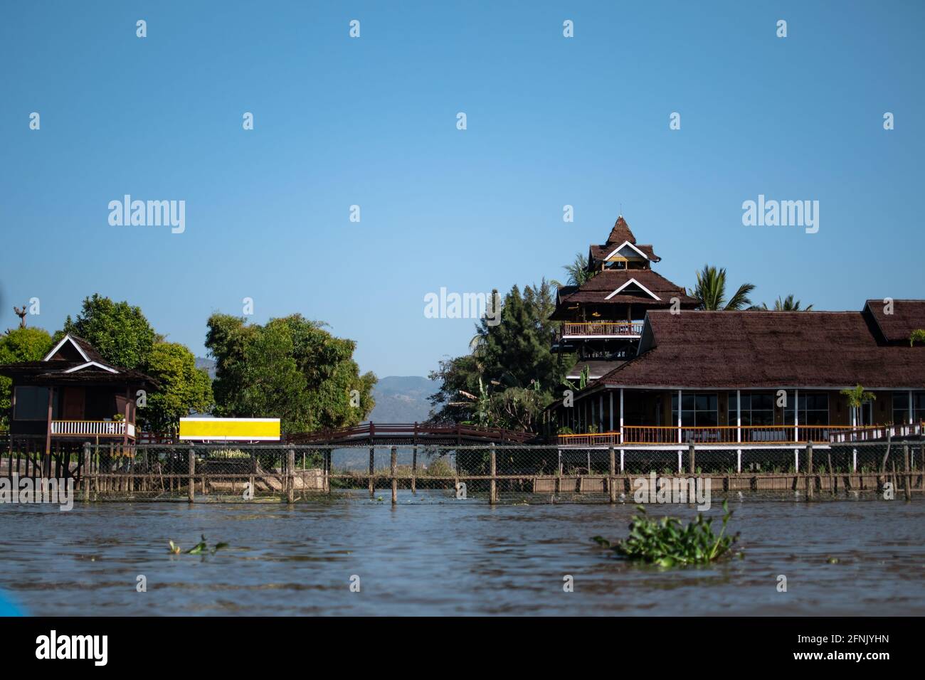 Red elevated buildings by the riverside of the canals at Inle Lake, Nyaung Shwe, Shan state, Mayanmar Stock Photo
