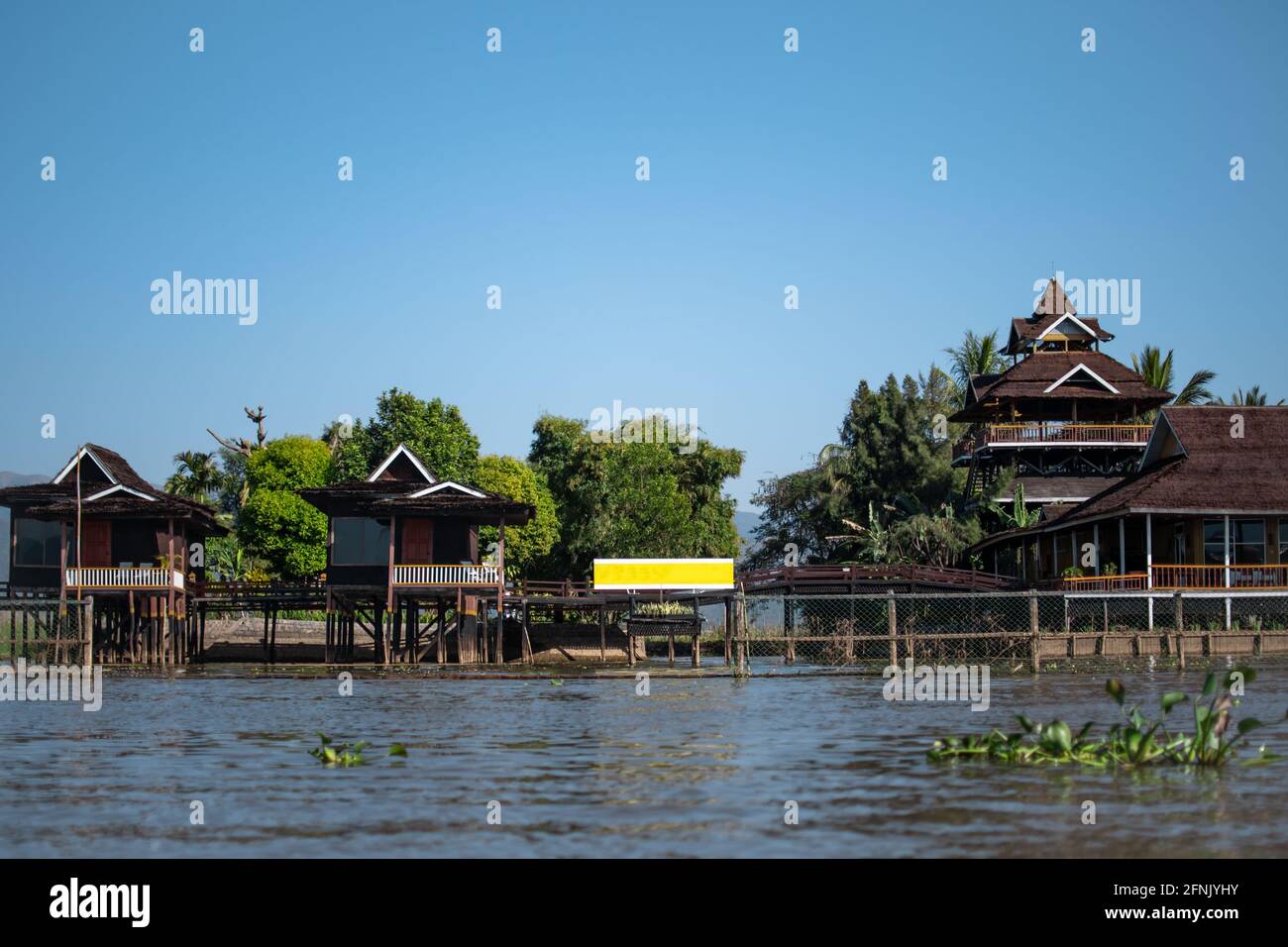 Red elevated buildings by the riverside of the canals at Inle Lake, Nyaung Shwe, Shan state, Mayanmar Stock Photo