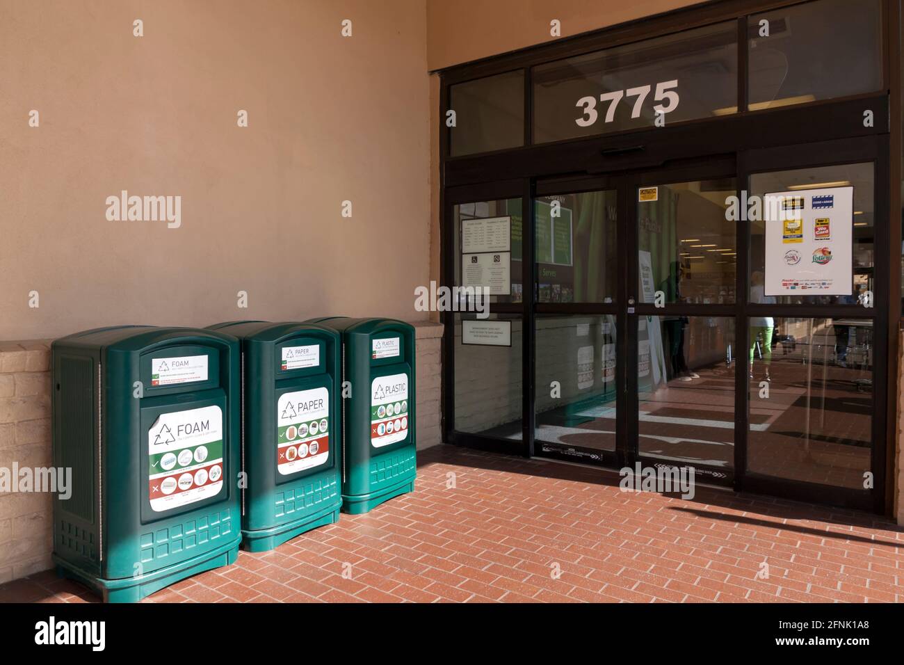 Three types of recycling bins (foam, paper, and plastic) outside of a