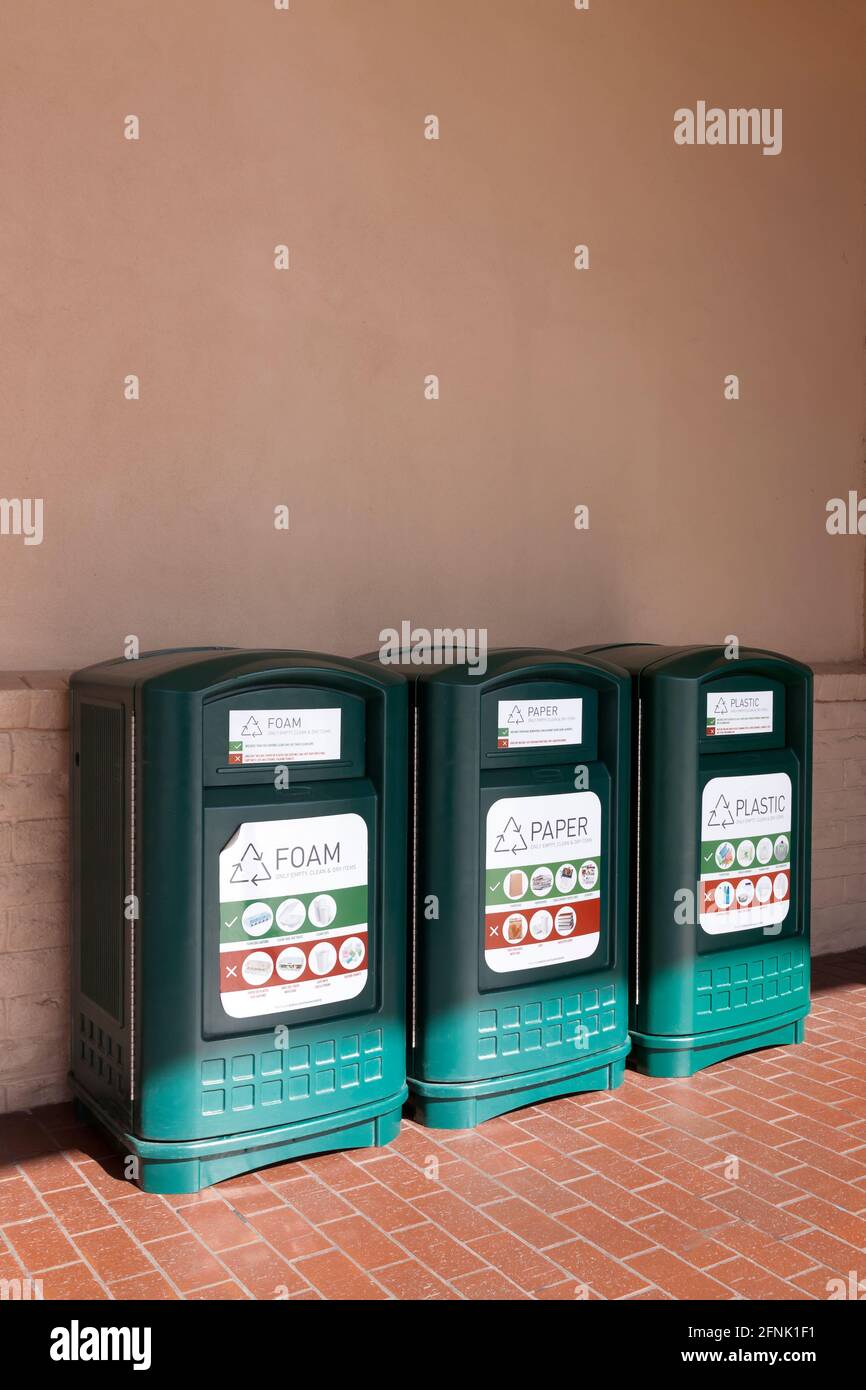 Three types of recycling bins (foam, paper, and plastic) outside of a