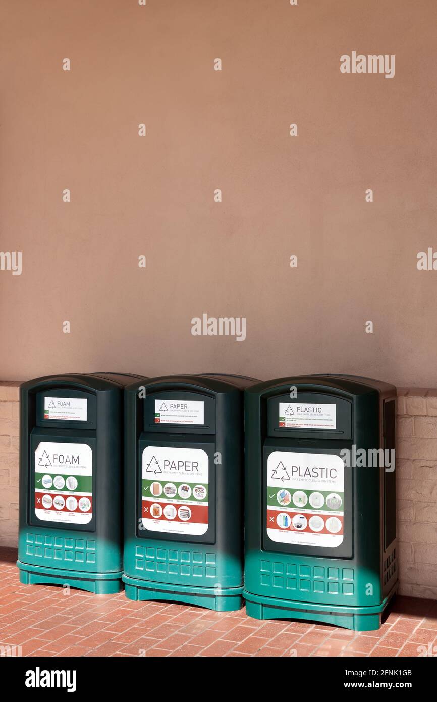 Three types of recycling bins (foam, paper, and plastic) outside of a
