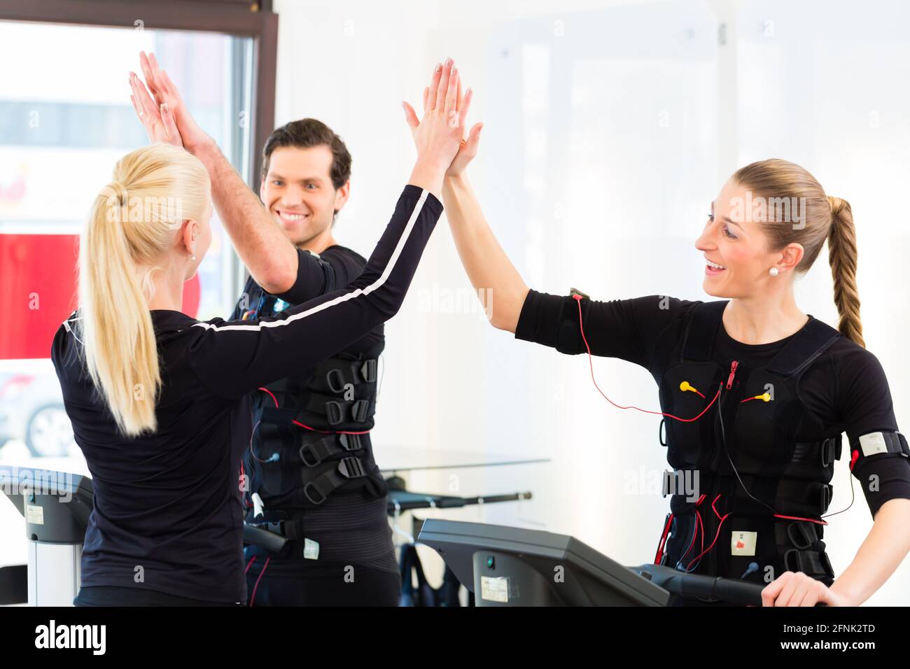 Nms Exercise Female coach giving man and woman nms electro muscular stimulation ...