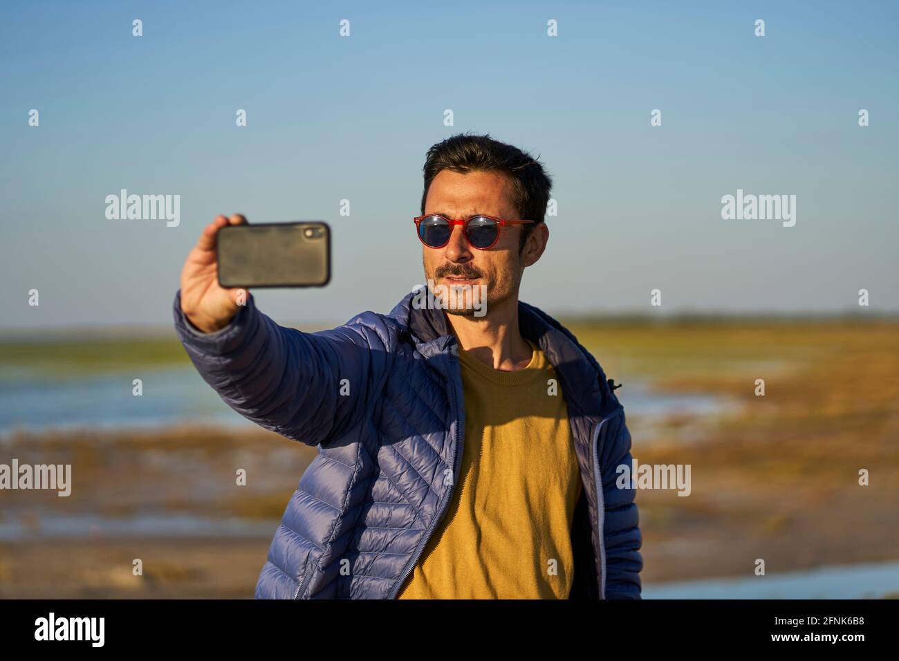 young man taking a selfie on the beach Stock Photo
