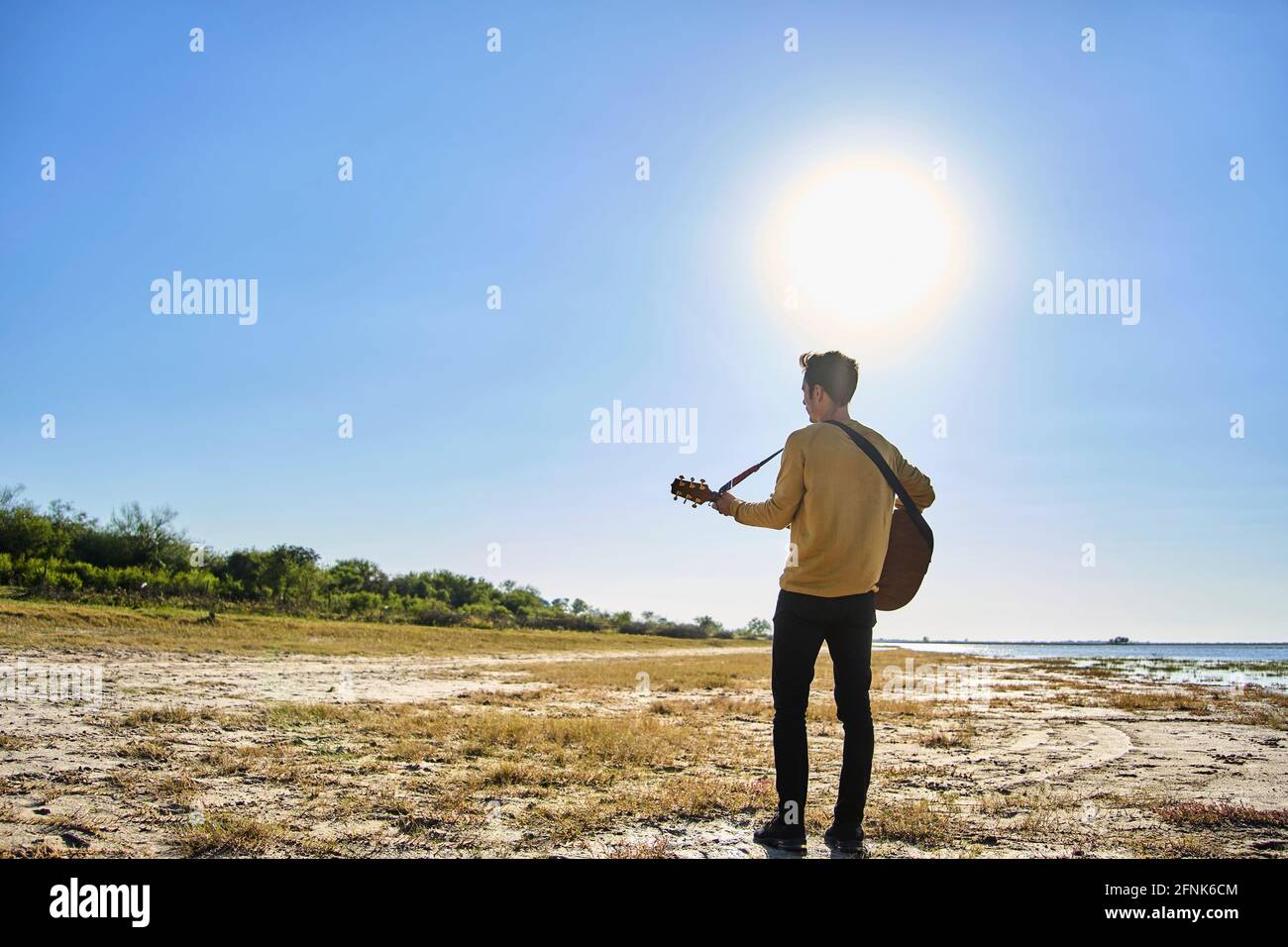 young man playing guitar in wild pl Stock Photo