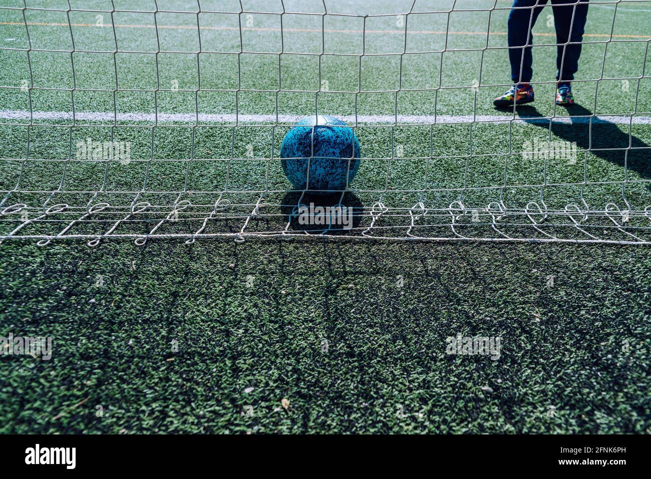 Soccer player in a goal tries to stop a ball, background with copy