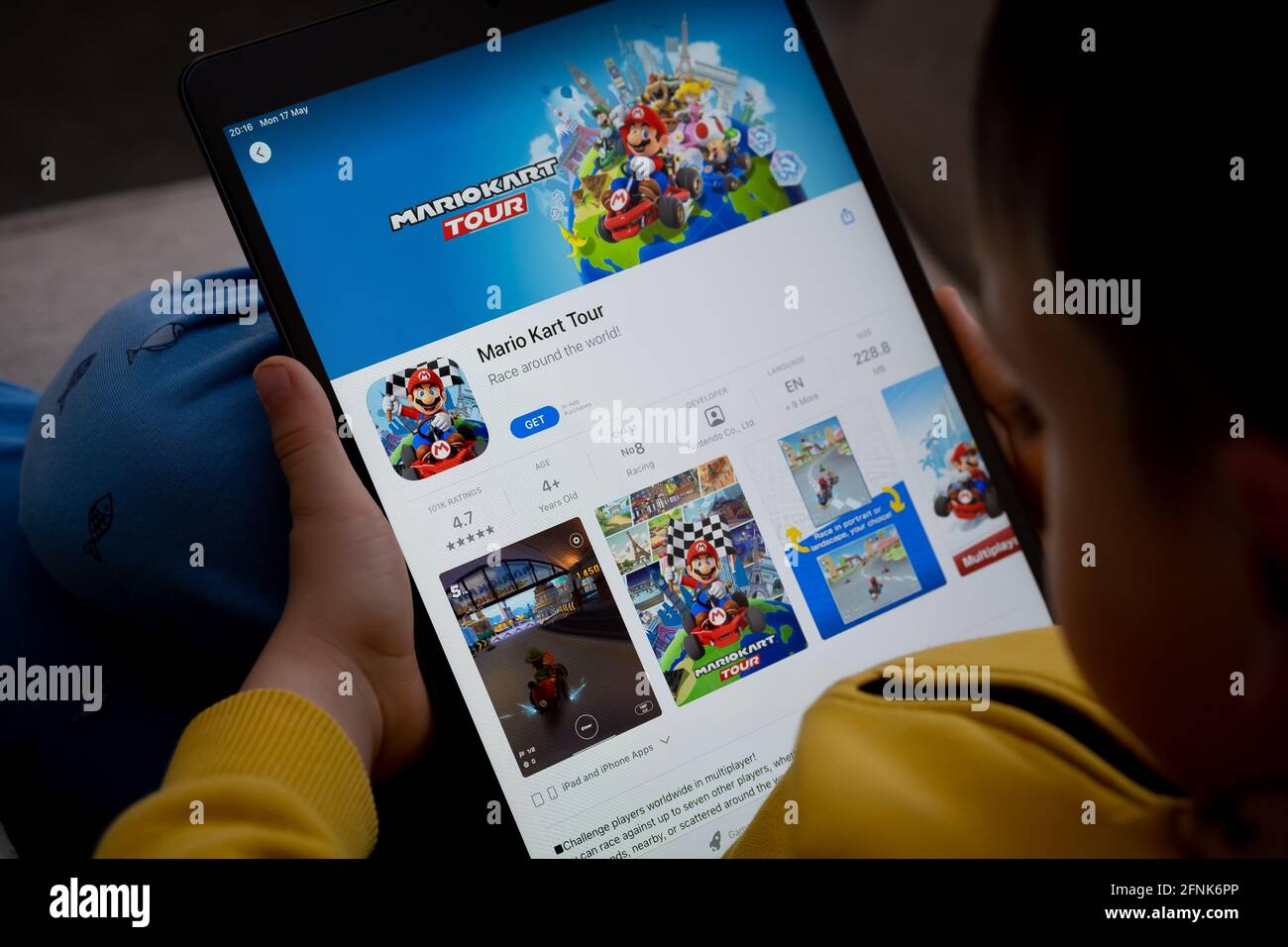 Mario Kart Tour game app seen on the screen of ipad which is in the hands of  unrecognisable child. Concept. Stafford, United Kingdom, May 18, 2021. Stock Photo