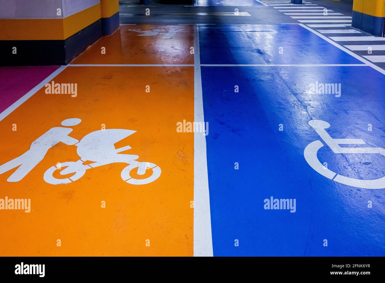 Parking spaces reserved for families and the disabled in a covered car park. Stock Photo