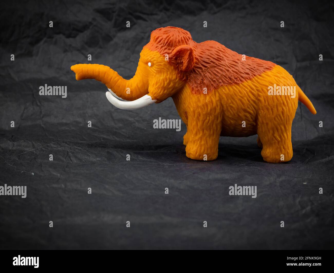 small toy mammoth on dark background Stock Photo