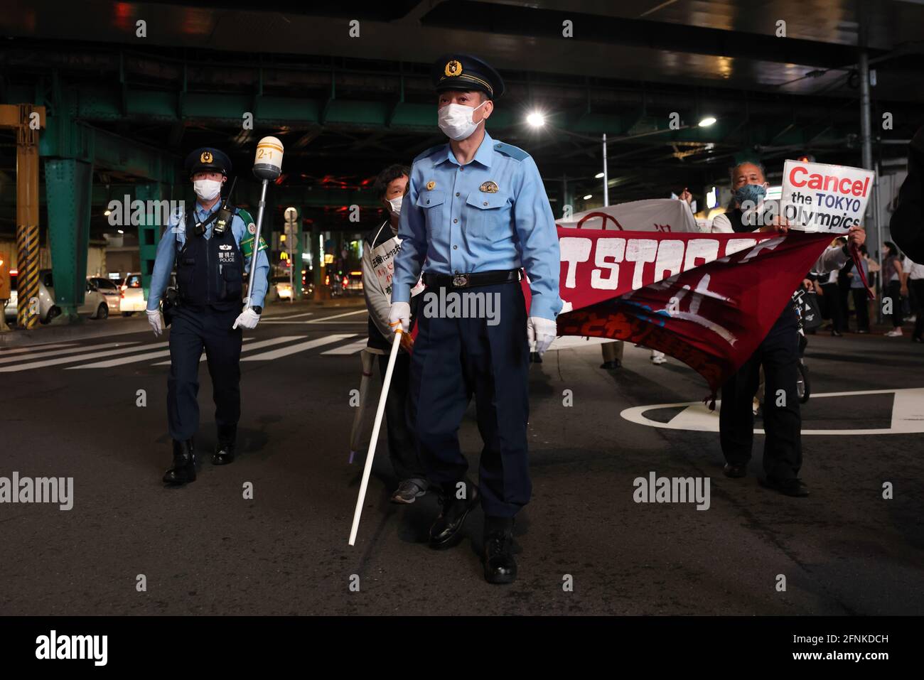 Tokyo, Japan. 17th May, 2021. Police officers lead the way for protesters during an anti Tokyo 2020 Olympic Games Rally in Ginza district.Around 30 to 40 protesters took to the streets calling for the cancelation of the Olympic Games this summer. They were accompanied by the same number of police officers. Protesters went from Shinbashi station through the Ginza district to the Head Office of the Organization Committee for the Games. Credit: SOPA Images Limited/Alamy Live News Stock Photo