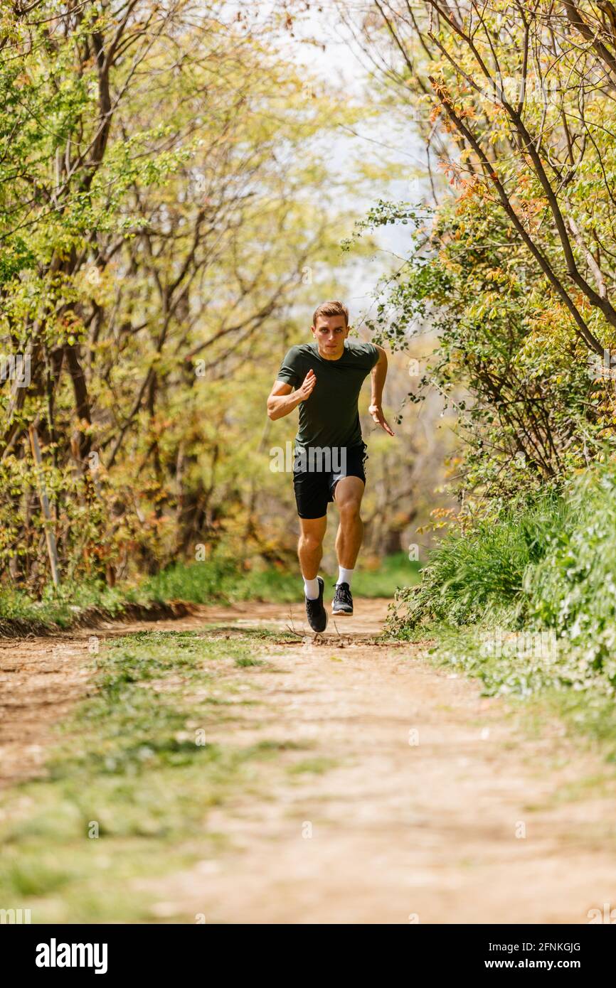 Sport man running. Portrait of runner man jogging in park. Sport