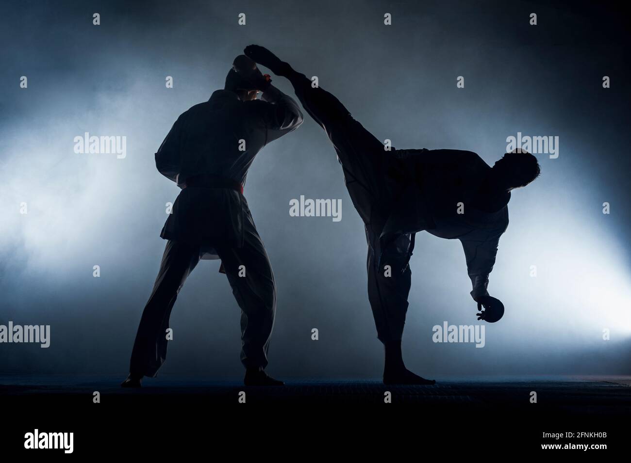 A young strong man in a white kimono for sambo, jiu jitsu and other