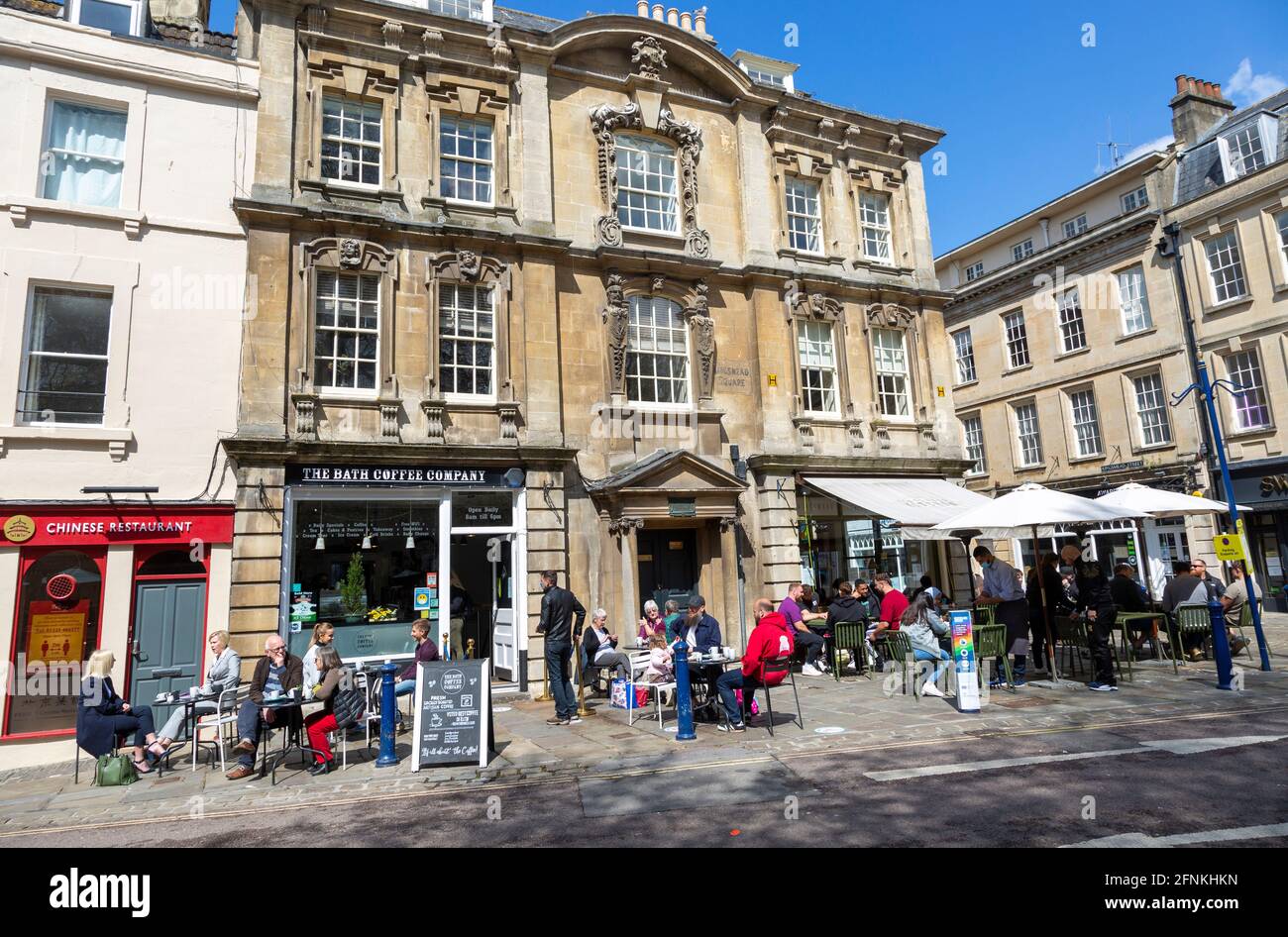 People sitting  in sunshine outside cafes, Kingsmead Square, Bath, Somerset, England, UK Stock Photo