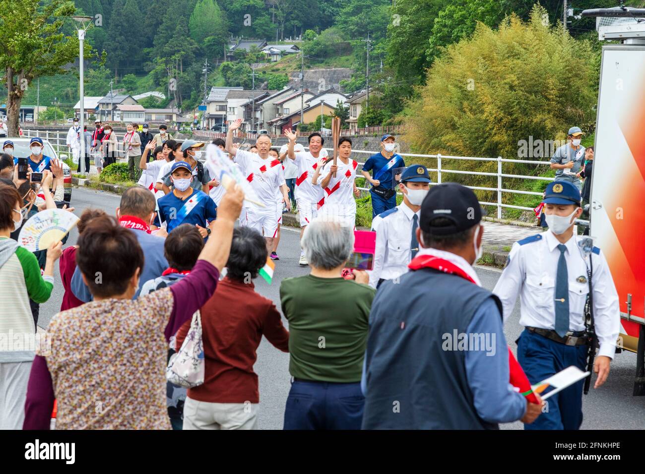 Local torchbearers run during the Tokyo 2020 Olympic torch relay in Okuizumo Town, Shimane Prefecture, Japan on May 16, 2021. Credit: Ryoji Okamoto/AFLO/Alamy Live News Stock Photo
