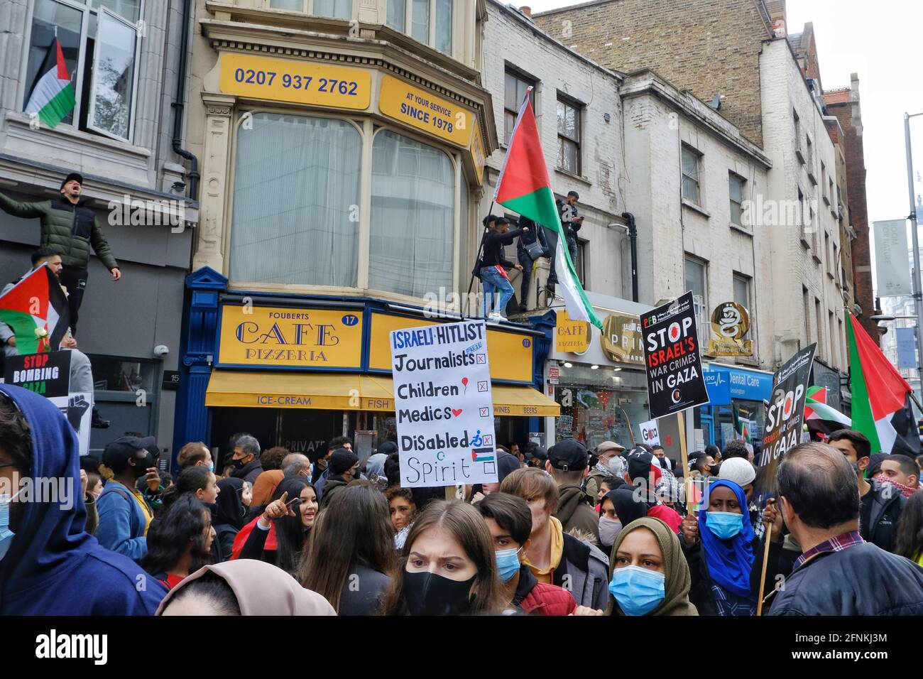 London, UK. 15/05/21 Palestinian supporters in London line the road and scale buildings close to the Israeli embassy during a protest. Stock Photo