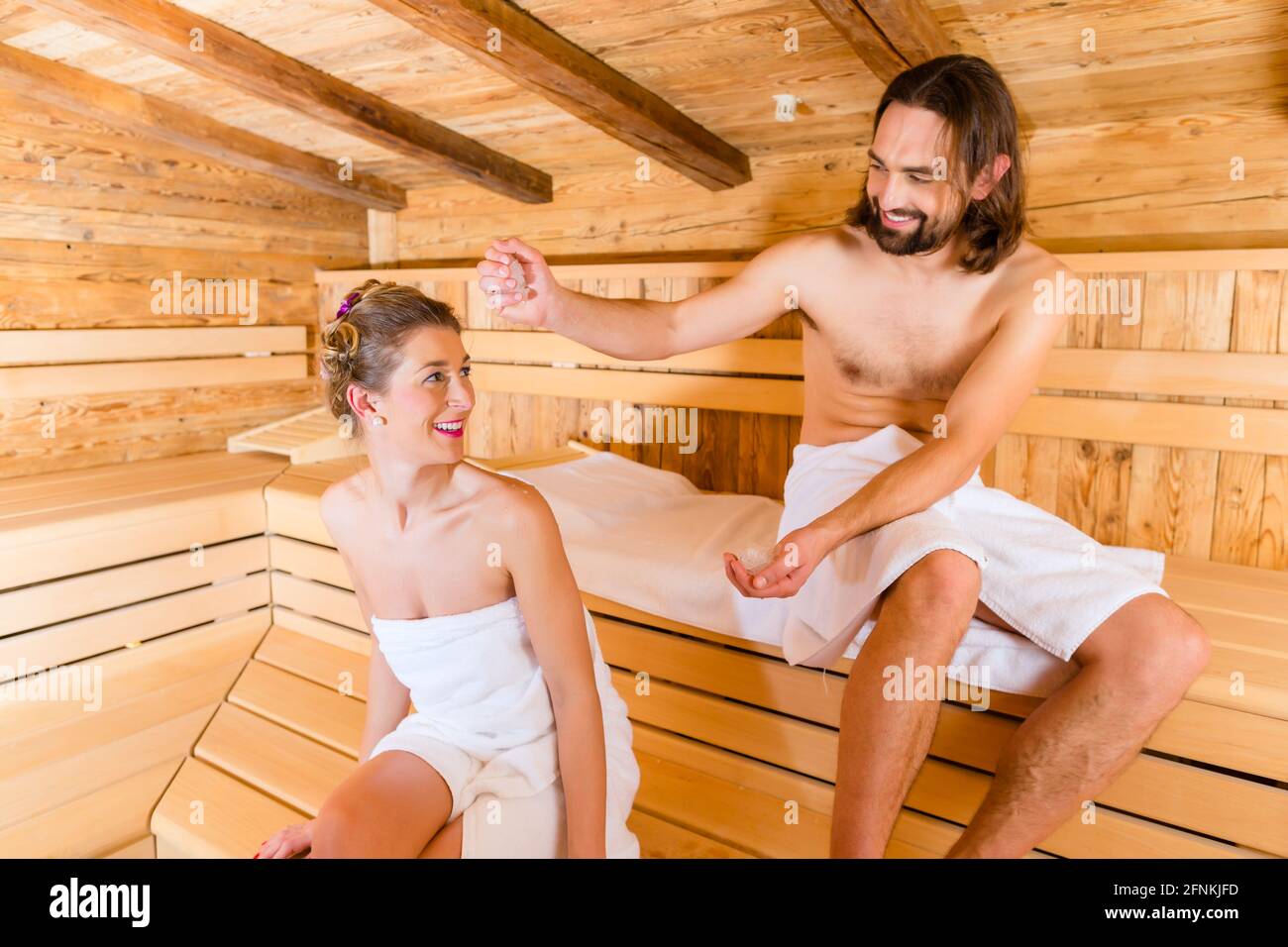 Couple relaxing together in wellness spa sauna with ice to cool down Stock Photo