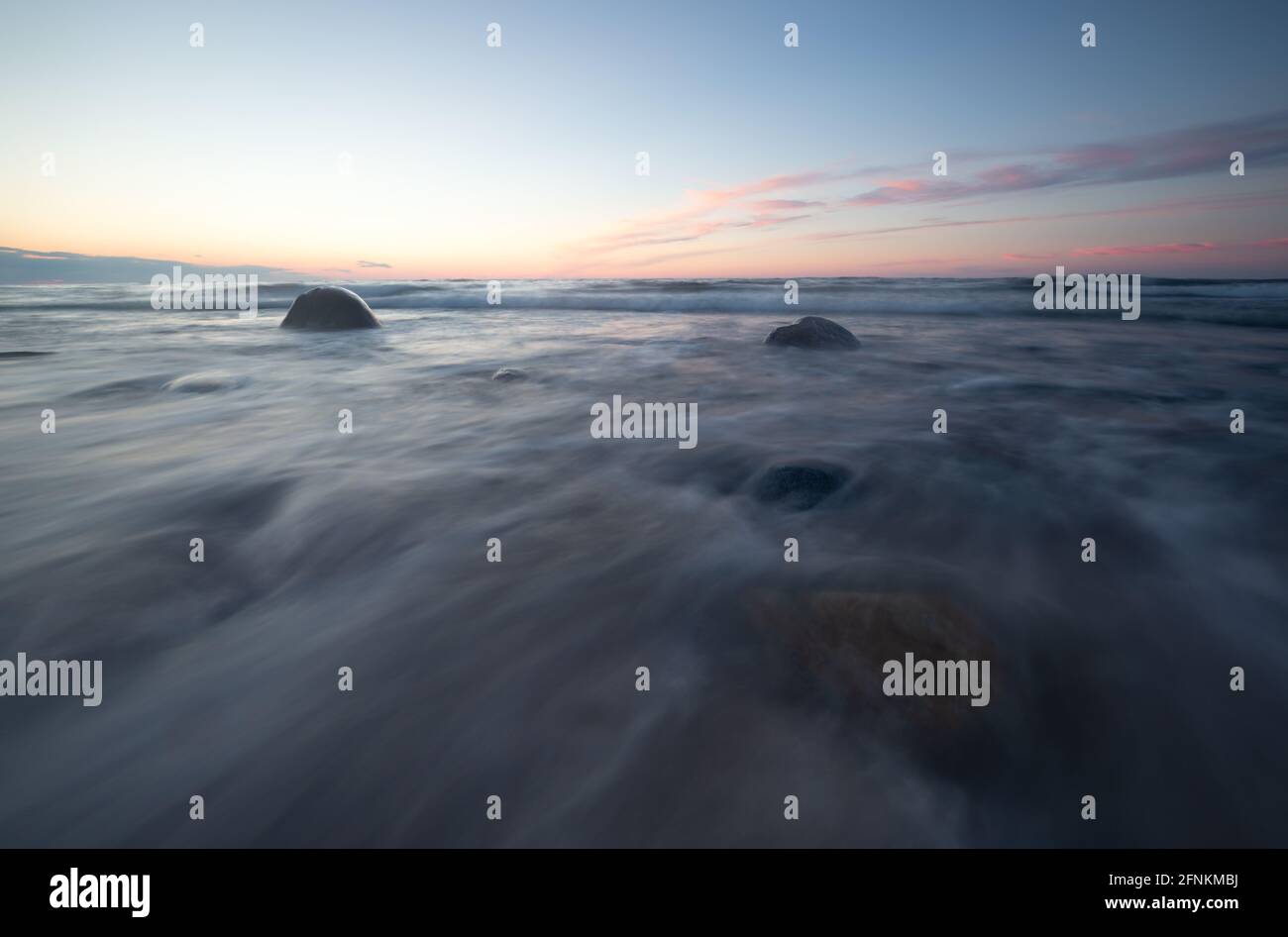 Beautiful ocean sunset with rocks and waves Stock Photo - Alamy