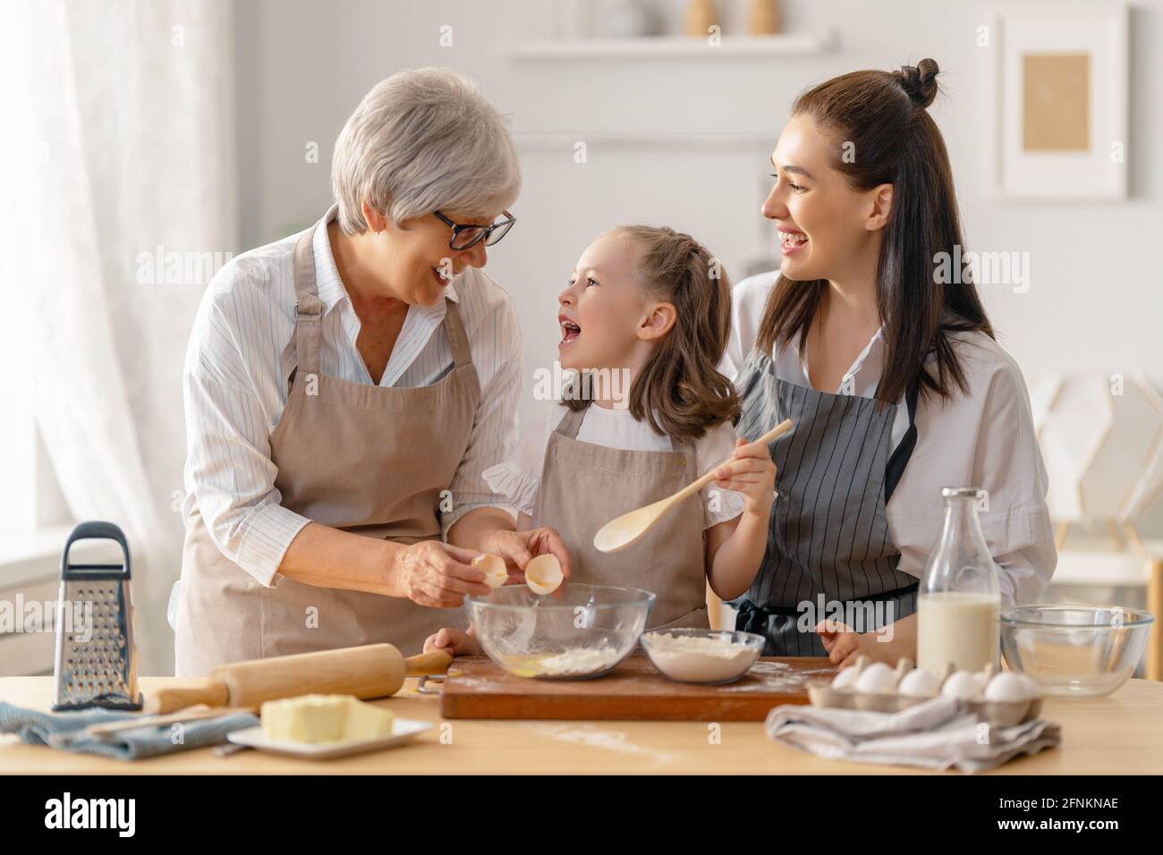https://c8.alamy.com/comp/2FNKNAE/happy-loving-family-are-preparing-bakery-together-granny-mom-and-child-are-cooking-cookies-and-having-fun-in-the-kitchen-homemade-food-and-little-h-2FNKNAE.jpg