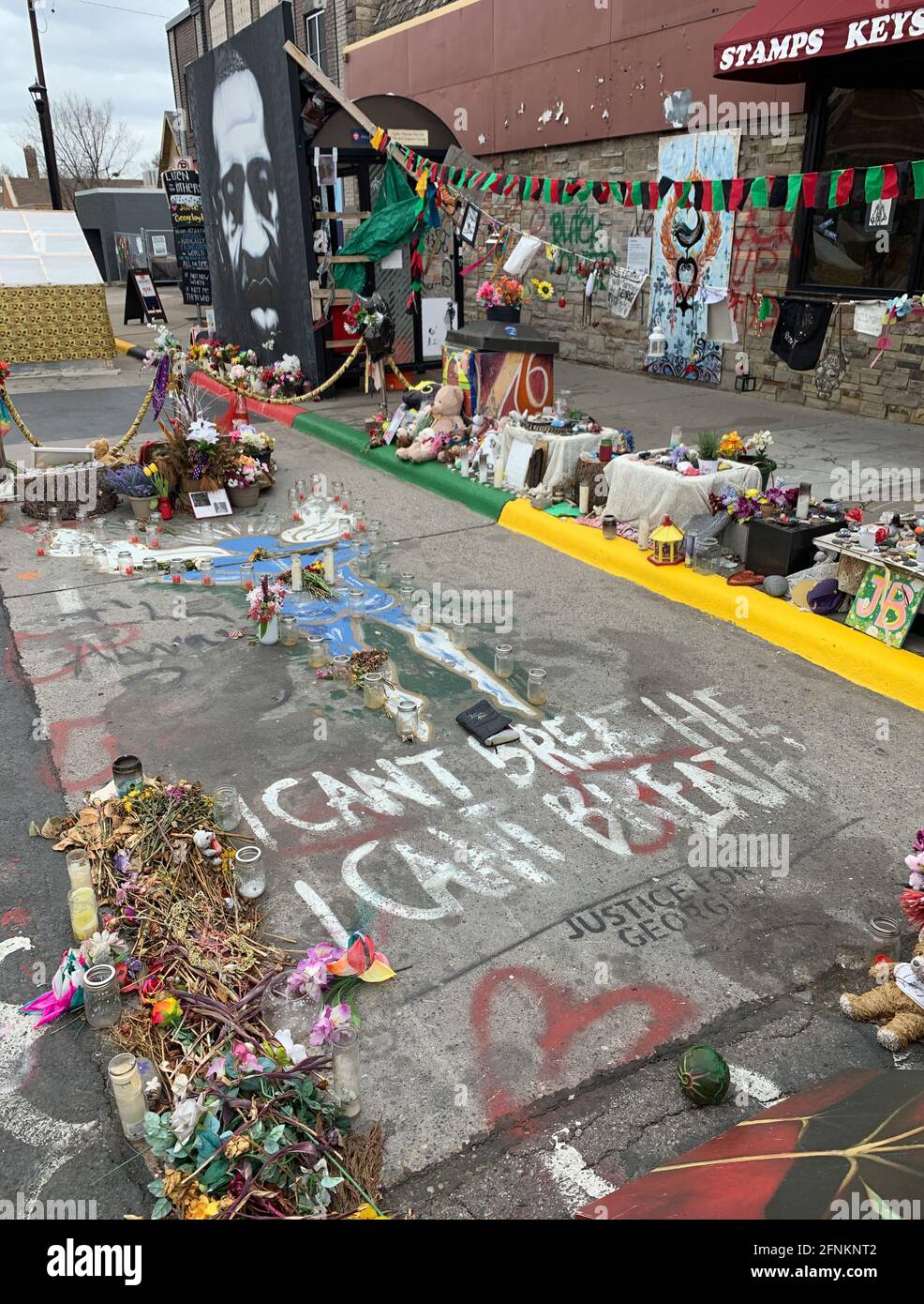 Minneapolis, USA. 20th Apr, 2021. The outline of a body has been painted on the asphalt and flowers, candles, and numerous other items lie in memory of the death of George Floyd at the site where he died. At the corner of 38th Street and Chicago Avenue in south Minneapolis, on May 25, 2020, African-American George Floyd was killed in the most brutal way by white police officer Chauvin in front of running cell phone cameras. (to dpa-Korr '9.5 minutes change the world: One year after George Floyd's death') Credit: Benno Schwinghammer/dpa/Alamy Live News Stock Photo