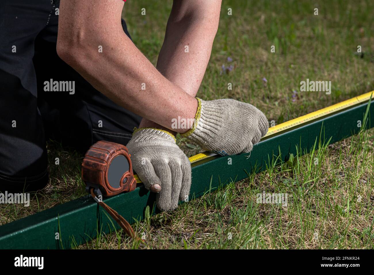 close-up of a male joiner measuring the incision with a ruler and ...