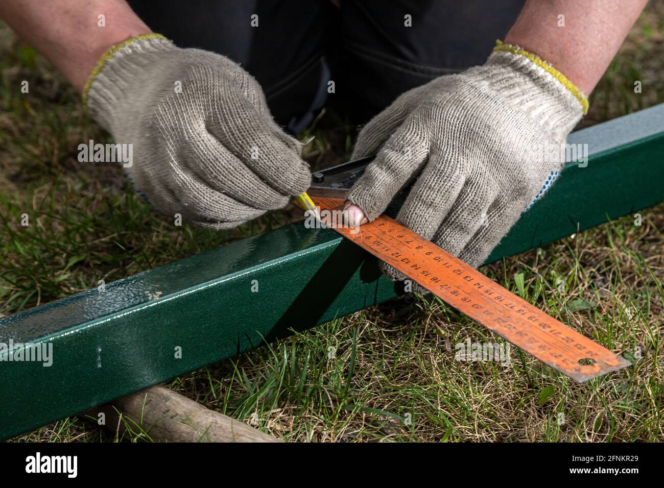 closeup of a male joiner measuring the incision with a ruler and