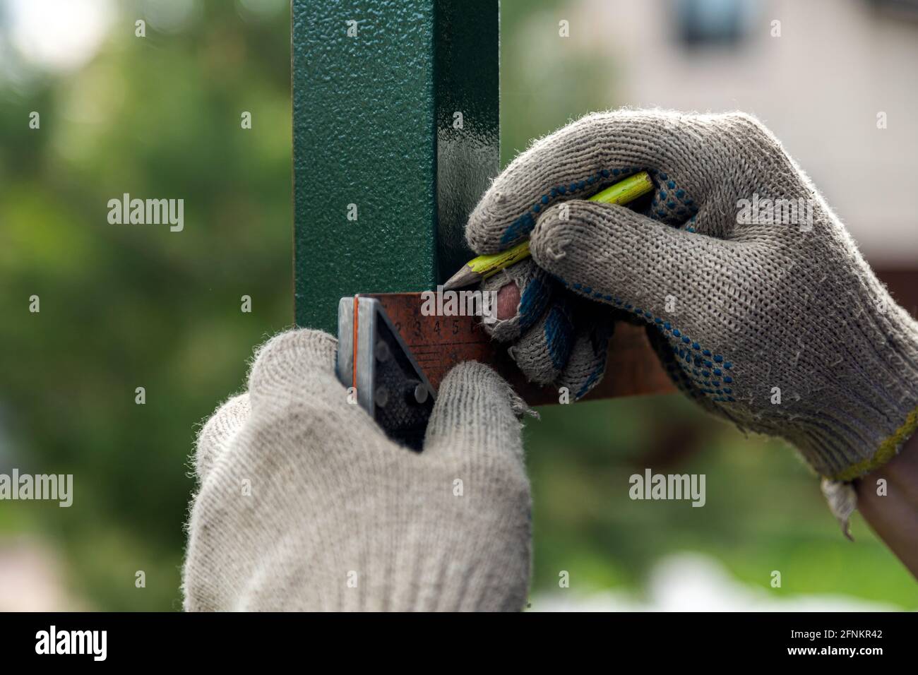 close-up of a male joiner measuring the incision with a ruler and ...