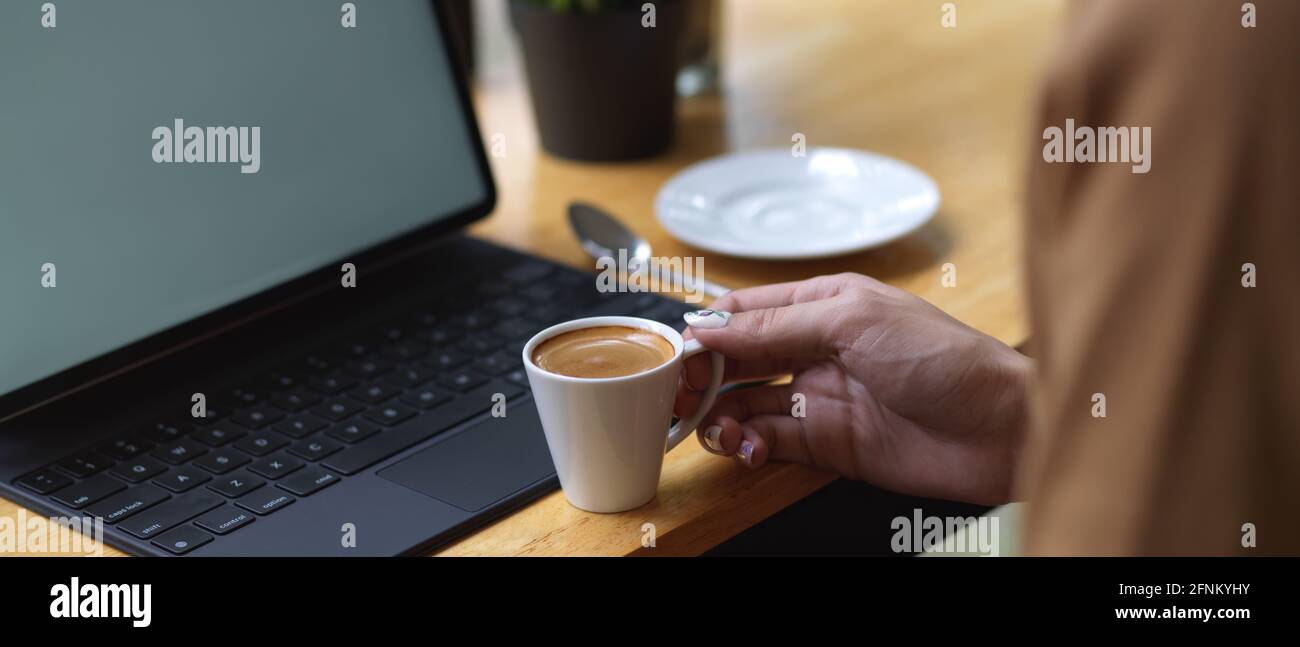 Close up view of female hand holding coffee cup on wooden bar with ...