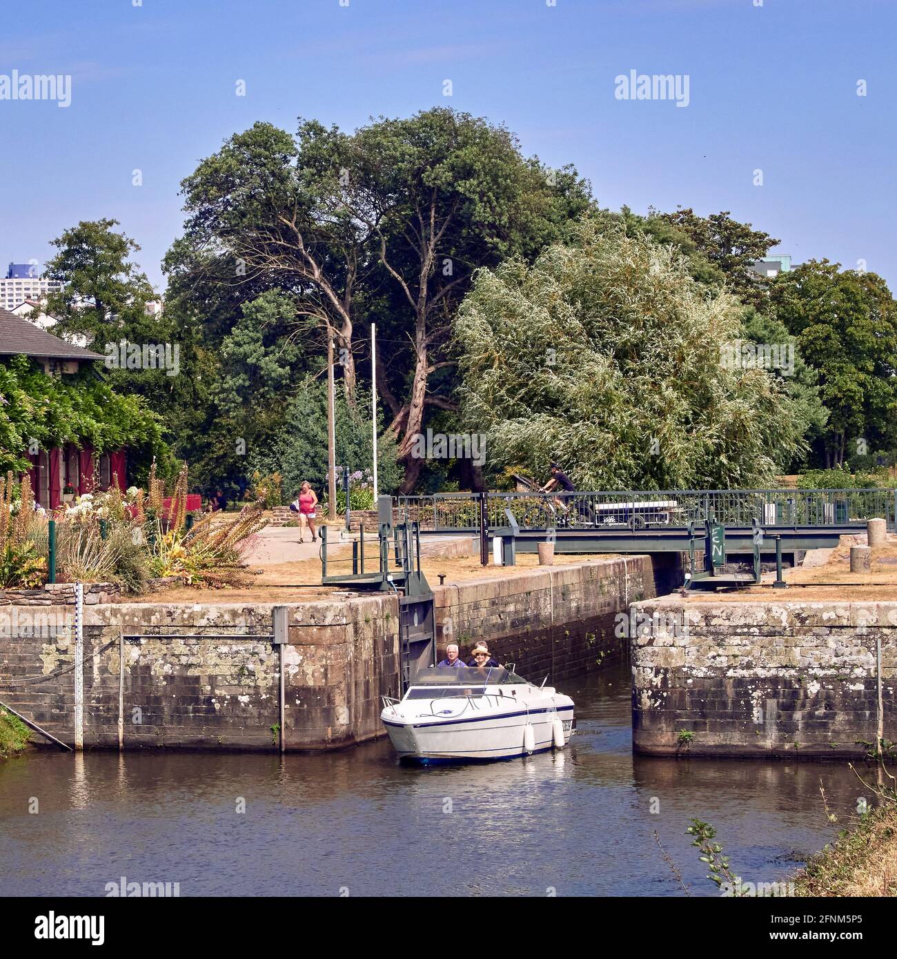 France. Rennes; city; Ille-et-Vilaine department, Brittany. A small motor boat leaves the first lock along the Vilaine river at the exit of Rennes tow Stock Photo