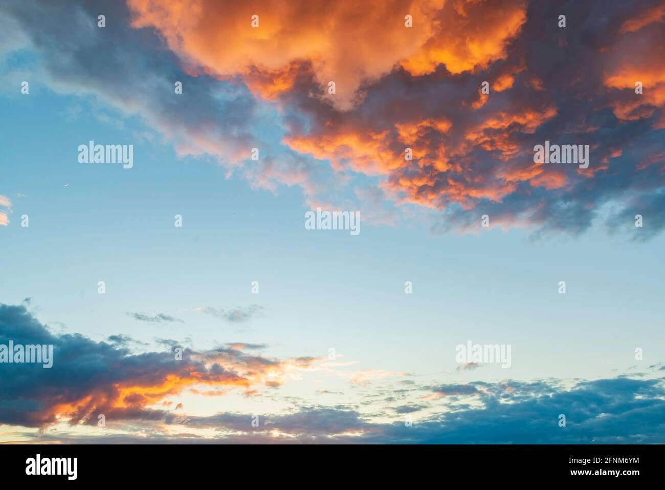 Epic clouds on the sunset. Dramatic orange clouds illuminated by sun. High resolution nature background Stock Photo