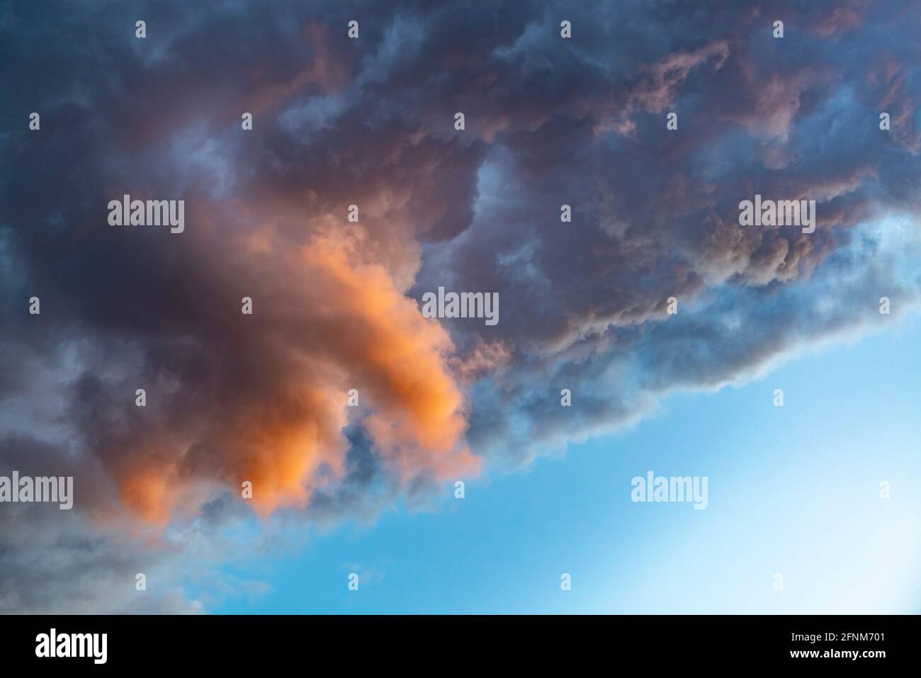 Dramatic rain clouds background. Colorful clouds on the sunset sky Stock Photo