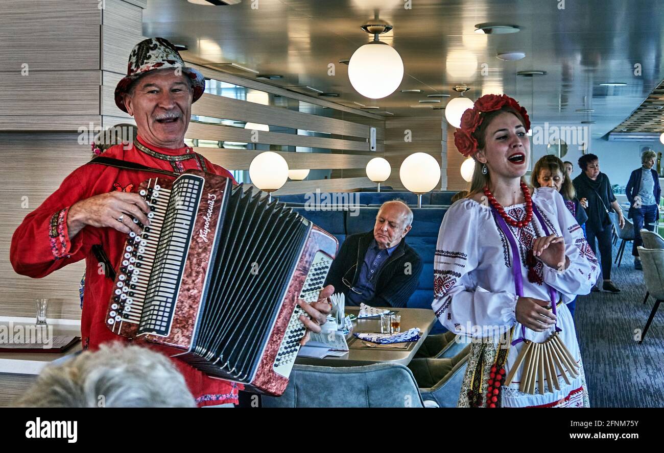 Russia ;Astrakhan Oblast. an accordion player and his singer animate the restaurant of a cruise ship on the Volgat river Stock Photo