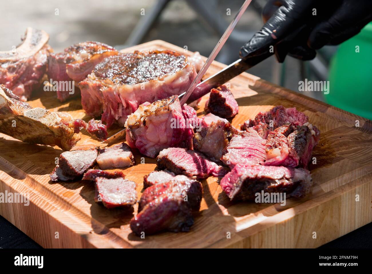 Chef de-boning and carving a portion of barbecued prime rib steak