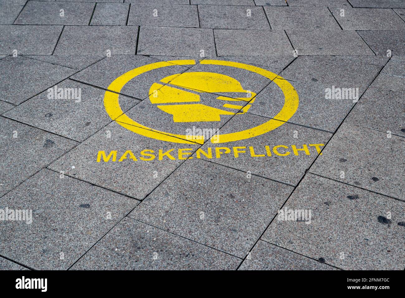 Yellow road marking Maskenpflicht Stock Photo