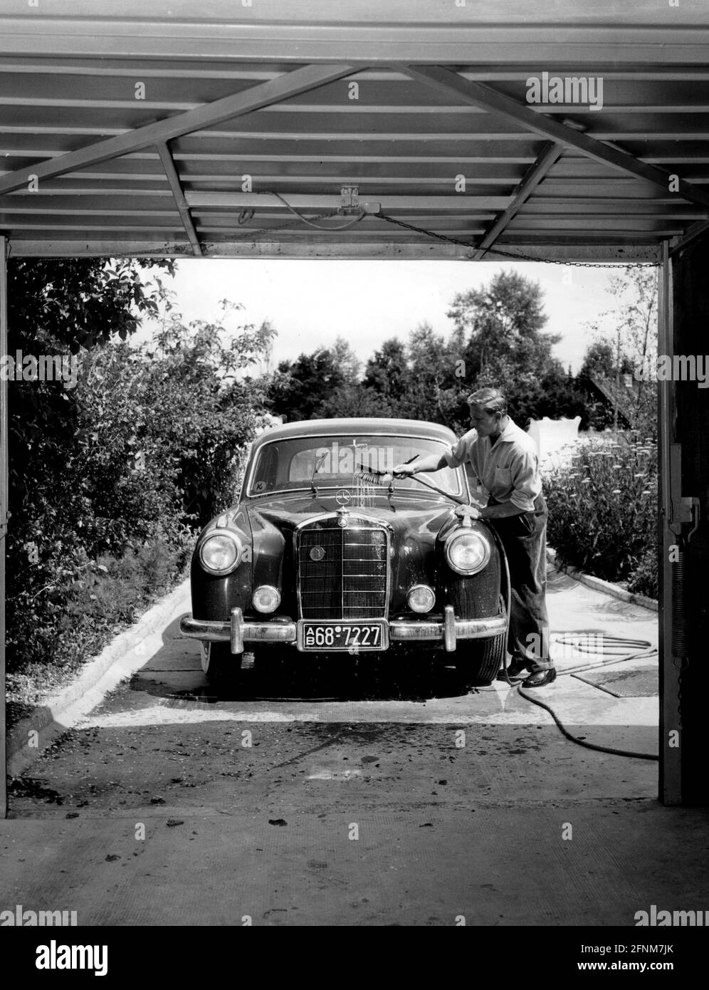 Borsche, Dieter, 25.10.1909 - 8.5.1982, German actor, full length, cleaning his car (Mercedes Benz), ADDITIONAL-RIGHTS-CLEARANCE-INFO-NOT-AVAILABLE Stock Photo