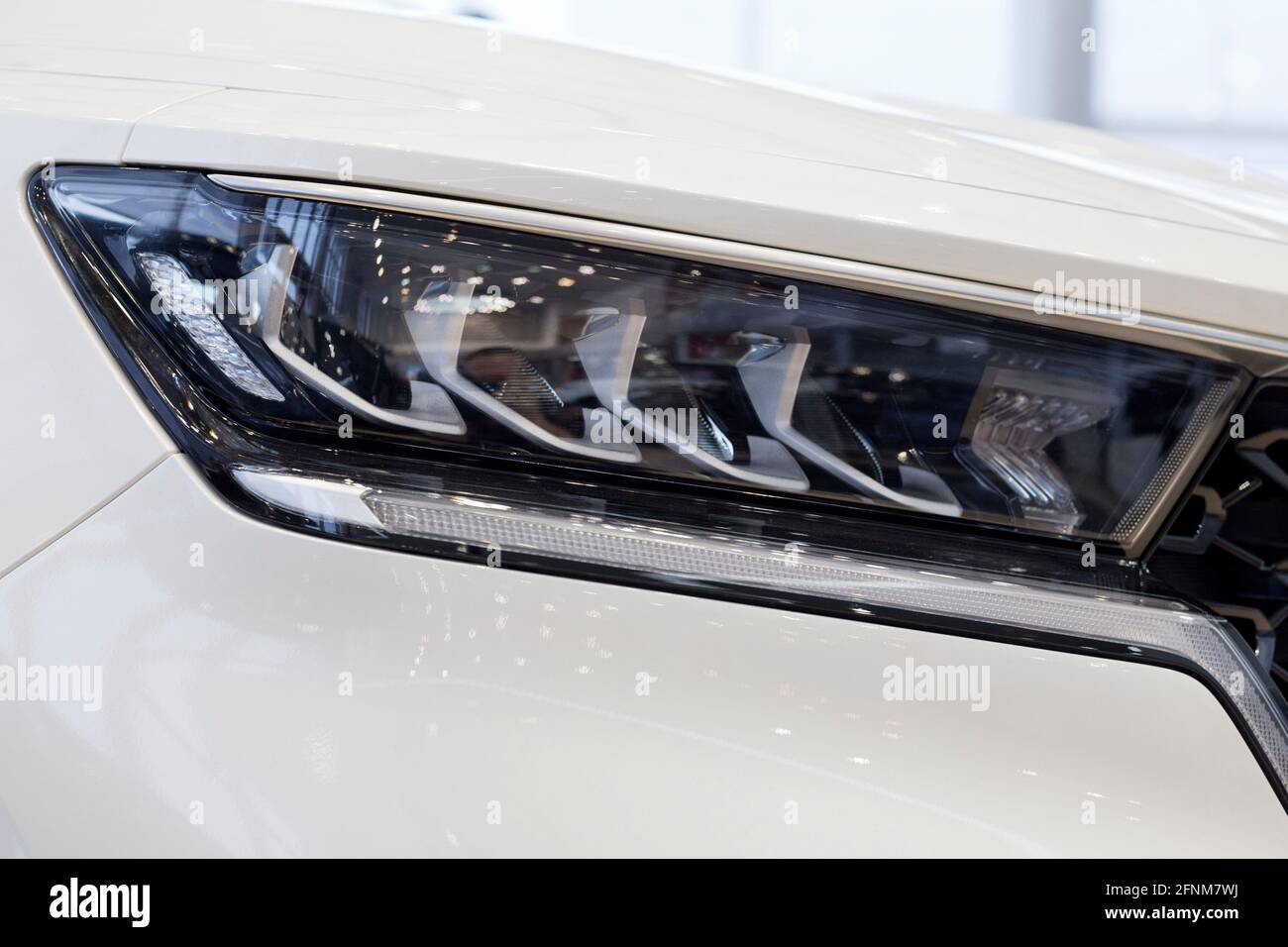 New modern unknown car with elegant head lamps. Cropped image. Close up. Modern transportation. Stock Photo