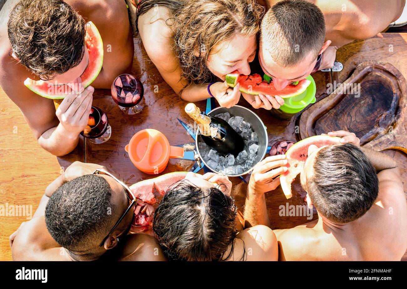 Top view of multiracial friend having fun at sail boat party with sangria watermelon champagne - Friendship concept with young multi racial people Stock Photo