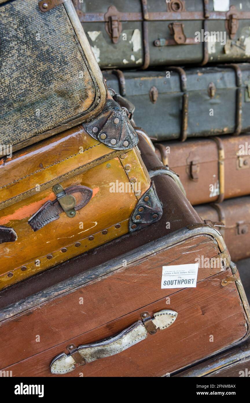 Old worn suitcases stacked on a railway platform, Great Central Railway, UK Stock Photo