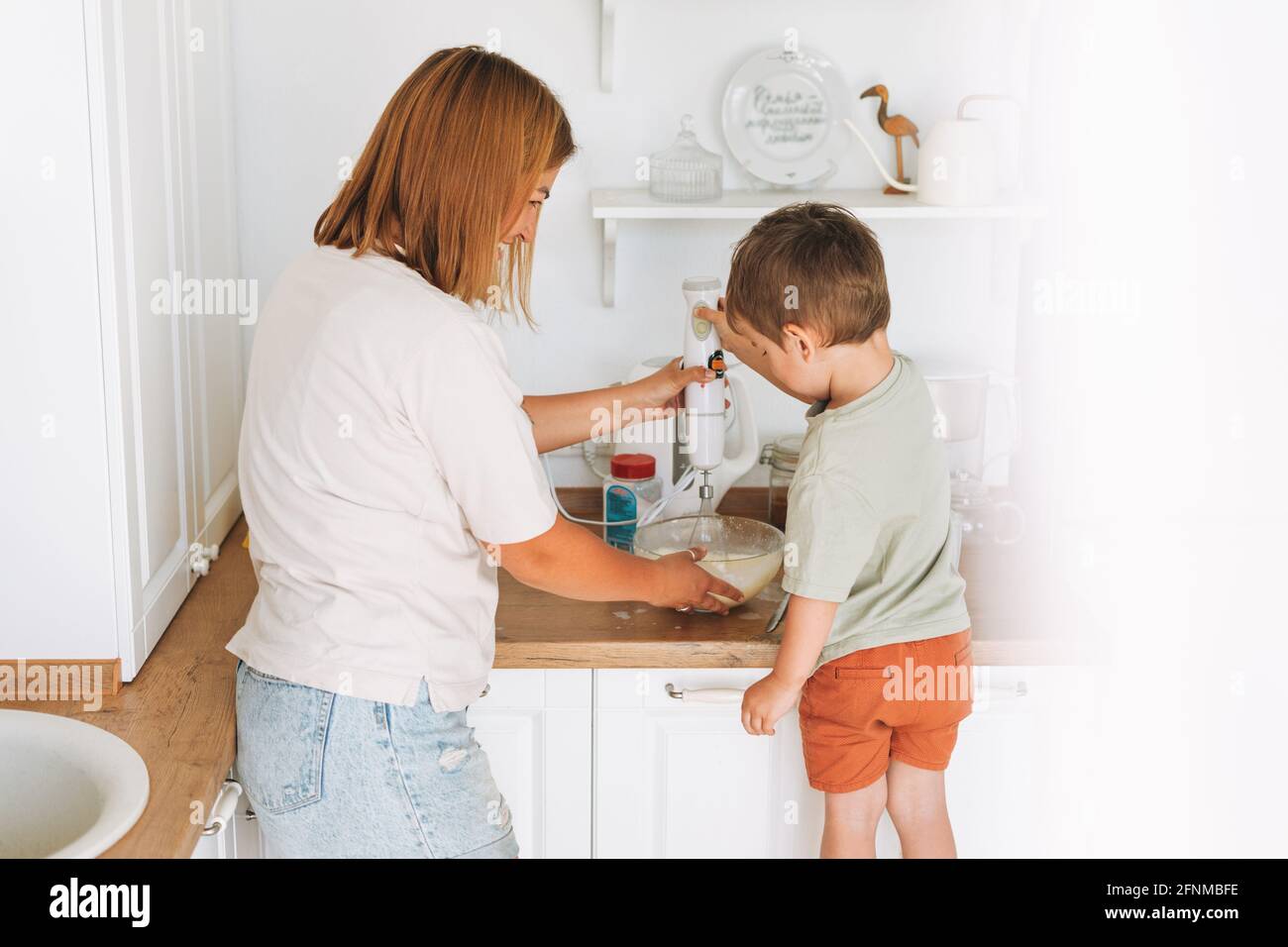 Young woman mother and her toddler boy son cooking with blender at the  table in kitchen at home Stock Photo - Alamy